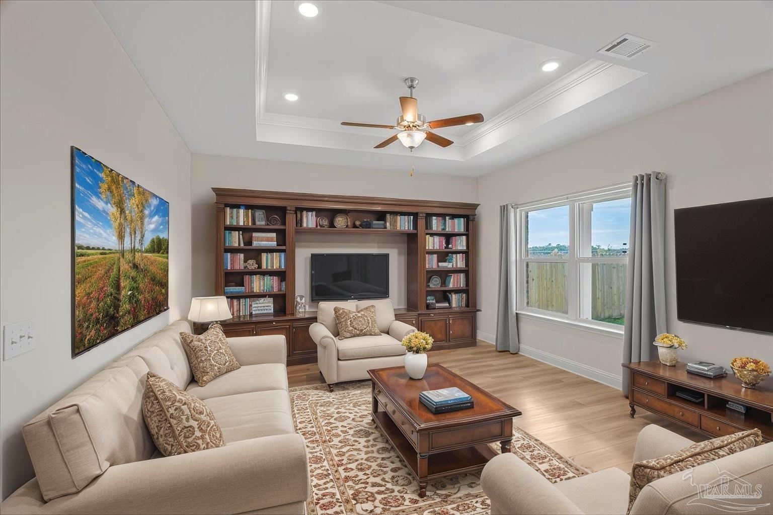 a living room with furniture ceiling fan and a flat screen tv