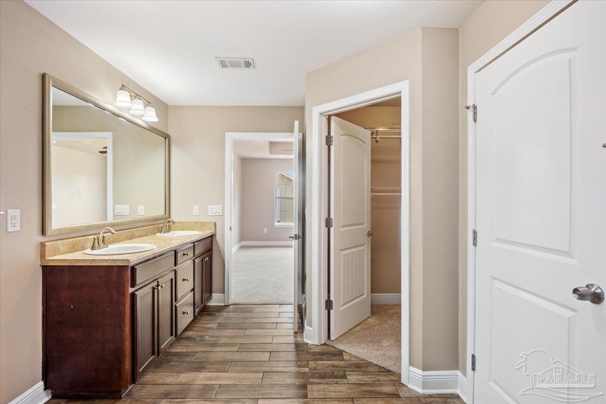 4015 Berry Circle Pace, FL 32571 - Photo 35 of 48 a bathroom with a double vanity sink and a mirror