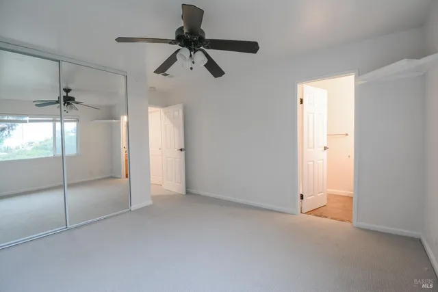 a view of an empty room and a fan