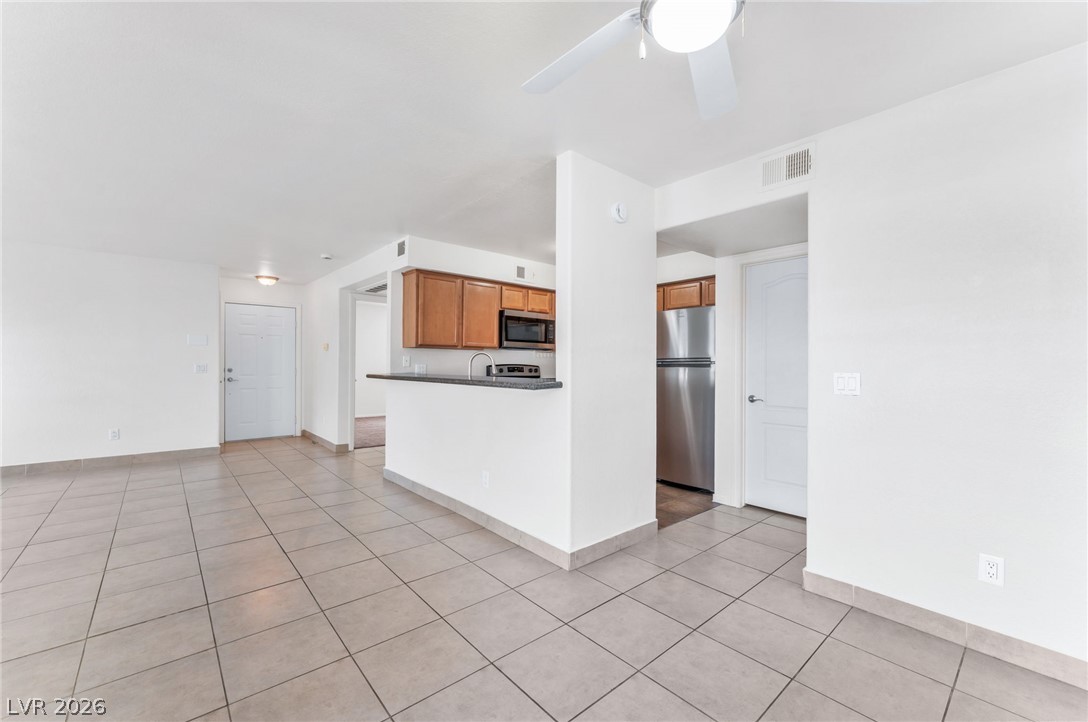 9325 West Desert Inn Road, Unit 177 Las Vegas, NV 89117 - Photo 7 of 24 An open layout connects the tiled living space directly to the kitchen area.