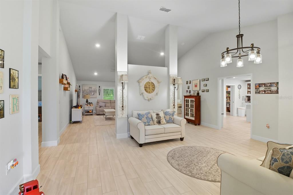 6788 Southwest 179th Ave Road Dunnellon, FL 34432 - Photo 4 of 23 a living room with furniture kitchen view and a chandelier