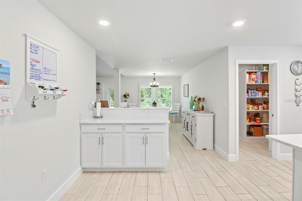 6788 Southwest 179th Ave Road Dunnellon, FL 34432 - Photo 10 of 23 a kitchen with white cabinets and wooden floor
