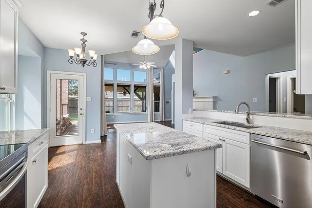 a kitchen with center island wooden floor and stainless steel appliances
