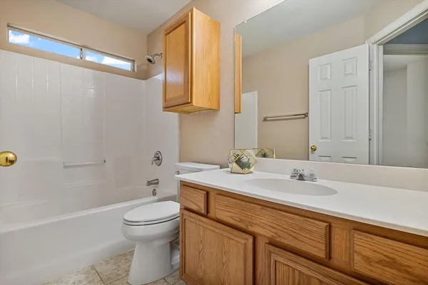 a bathroom with a granite countertop sink a toilet and a bathtub