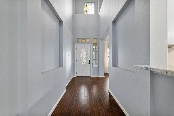 a view of a hallway with wooden floor and staircase