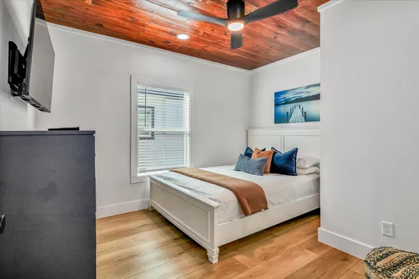 a bedroom with a bed and wooden floor