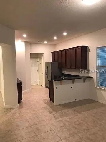 a view of kitchen with refrigerator sink and cabinets