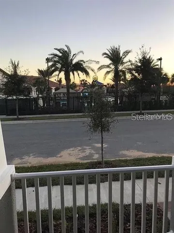 a view of balcony with wooden floor and palm trees