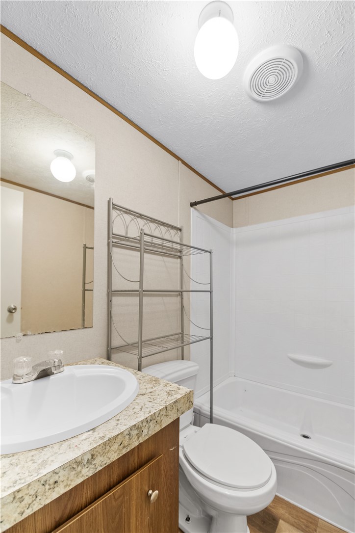 1188 Old Liberty Road Easley, SC 29640 - Photo 25 of 28 This bright bathroom features a clean vanity, full-sized tub, and natural wood cabinetry.