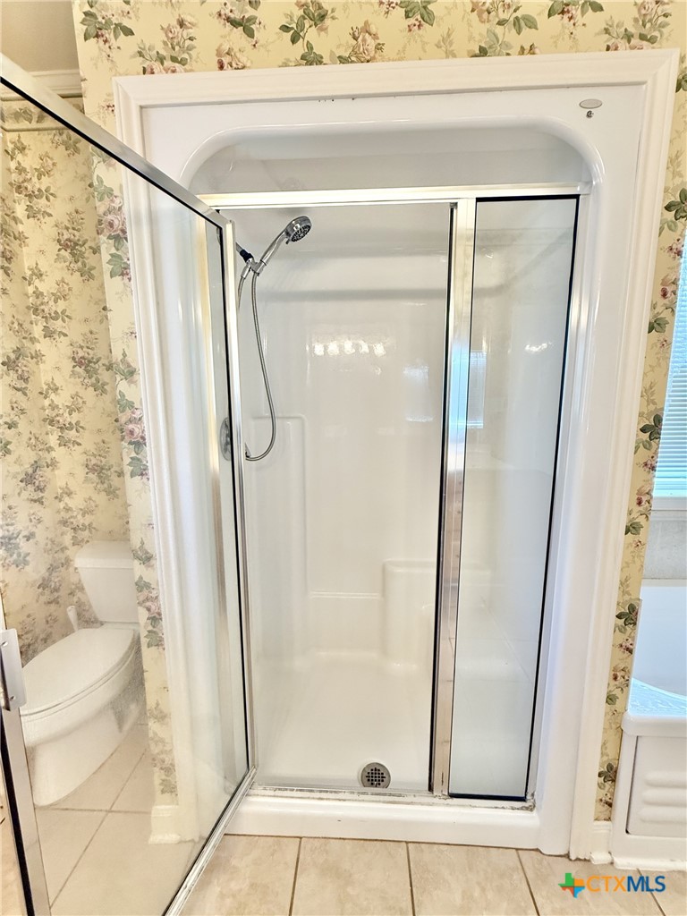 415 South Trinity Street Edna, TX 77957 - Photo 26 of 46 a bathroom with a glass shower door and a window