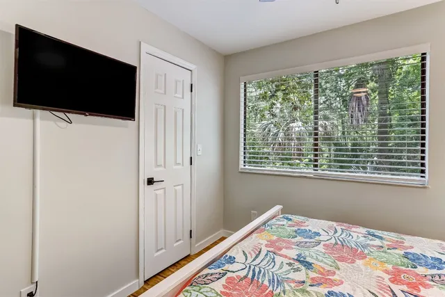 a bed room with a bed tv and a window