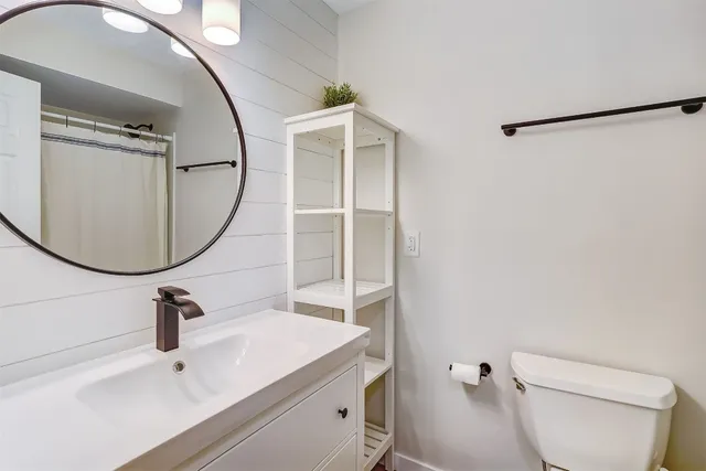 a bathroom with a sink a toilet and a mirror