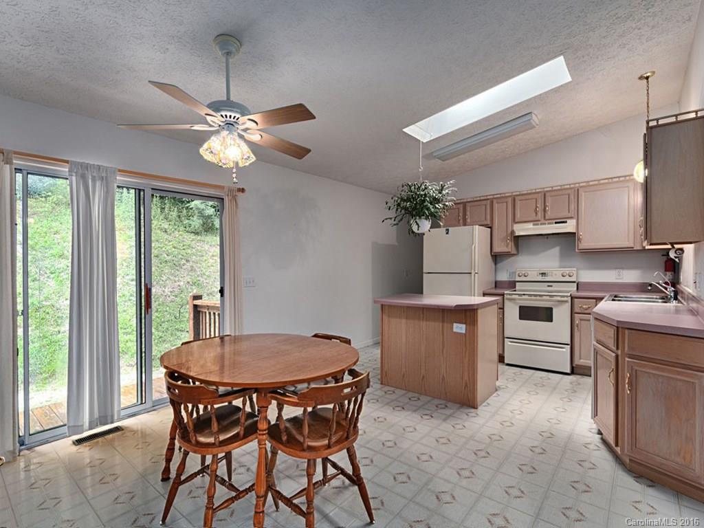 1059 Sugar Cove Road Clyde, NC 28721 - Photo 4 of 14 a kitchen with a table chairs and white cabinets