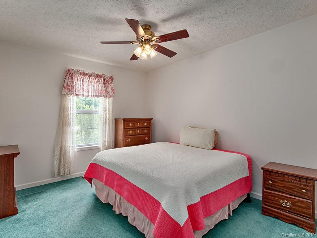 1059 Sugar Cove Road Clyde, NC 28721 - Photo 8 of 14 a bedroom with a bed and a chandelier