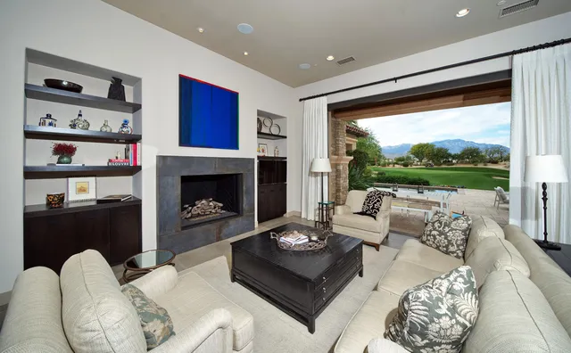 a living room with furniture a flat screen tv and a fireplace