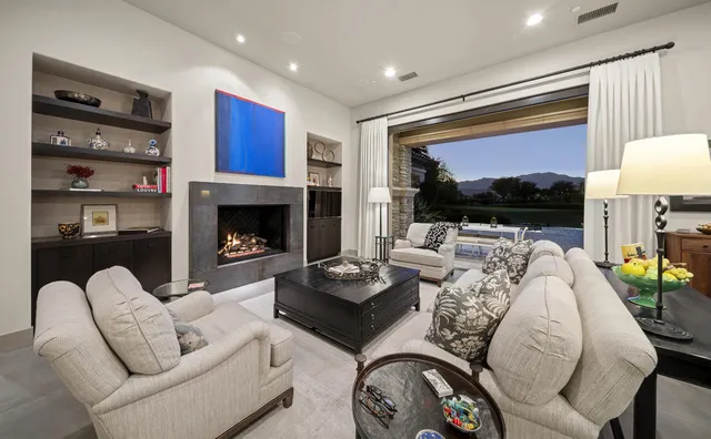 a view of a dining room with furniture a chandelier a flat screen tv and a chandelier