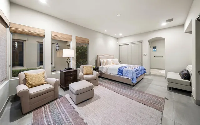 a spacious bedroom with a bed and a flat screen tv