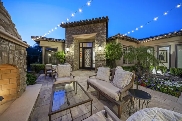 a view of a patio with couches table and chairs and potted plants