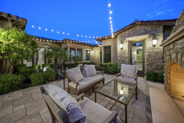 a view of a patio with couches table and chairs and potted plants