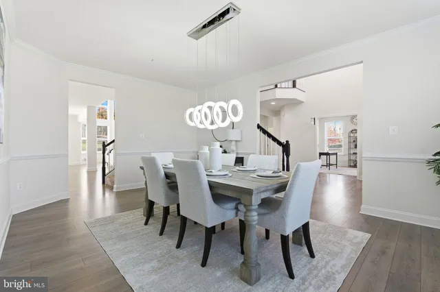 a view of staircase with lots of frames on wall and wooden floor