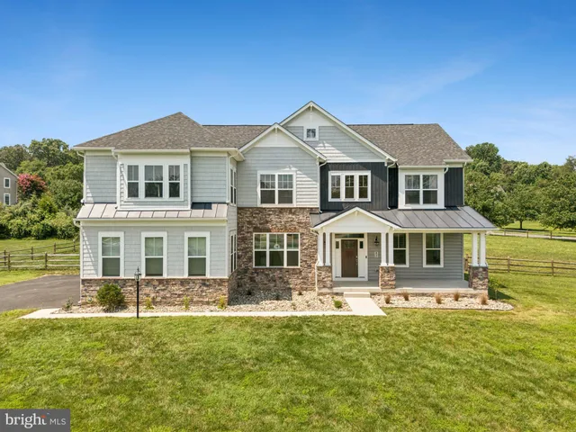 a kitchen with stainless steel appliances granite countertop a wooden floor a stove a sink and a refrigerator