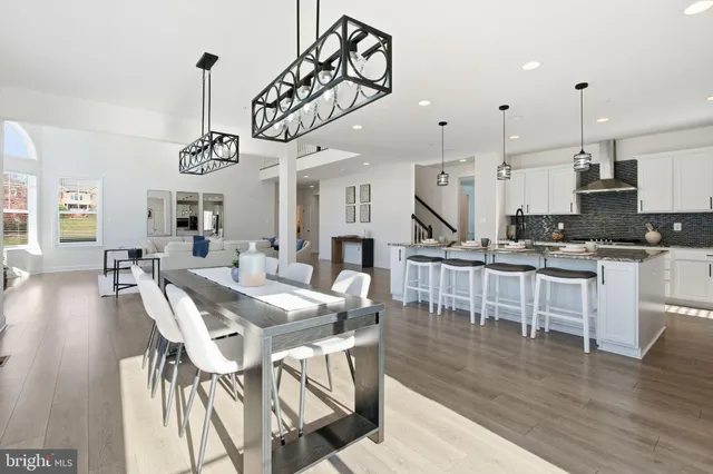 a kitchen with stainless steel appliances granite countertop a sink a stove and chairs