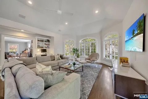 a living room with furniture wooden floor and a flat screen tv