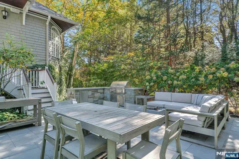 a roof deck with a table and chairs with wooden floor and fence