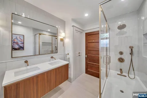 a bathroom with a tub sink and mirror