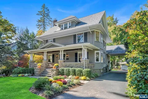 a front view of a house with a yard garden and outdoor seating