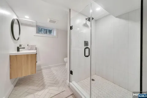 a bathroom with a granite countertop shower a mirror and a sink