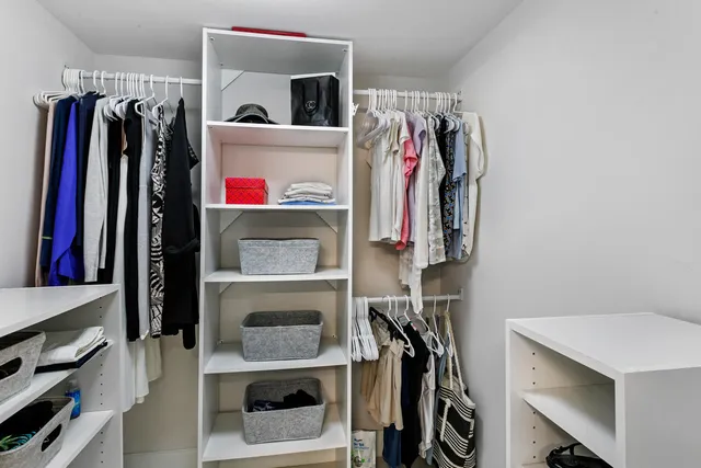a view of walk in closet with clothes and shoes
