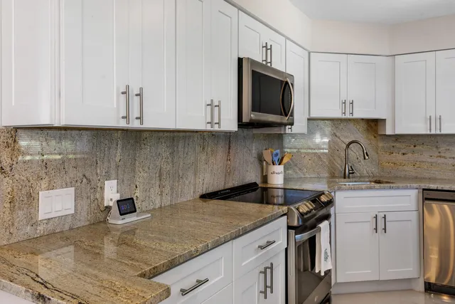 a kitchen with granite countertop a sink and a stove