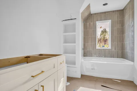 a bathroom with a tub sink and vanity