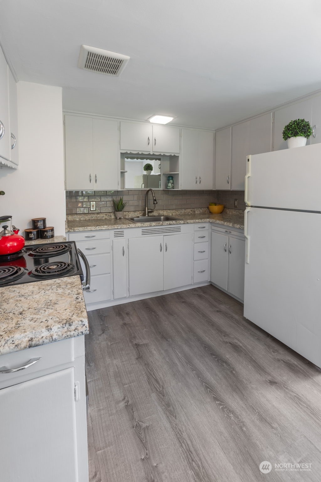 11616 6th Avenue Southwest Seattle, WA 98146 - Photo 4 of 37 a kitchen that has a sink and a stove in it