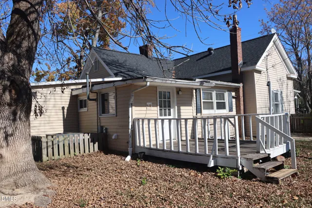 a view of a house with a small yard and wooden fence