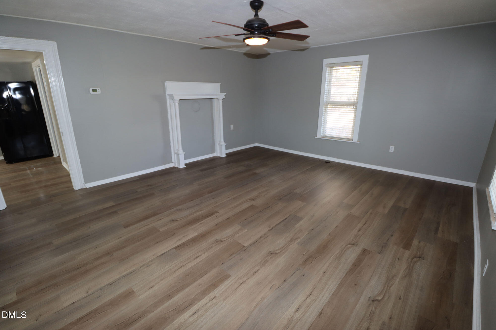 110 Emory Street Garner, NC 27529 - Photo 6 of 22 an empty room with wooden floor fan and windows