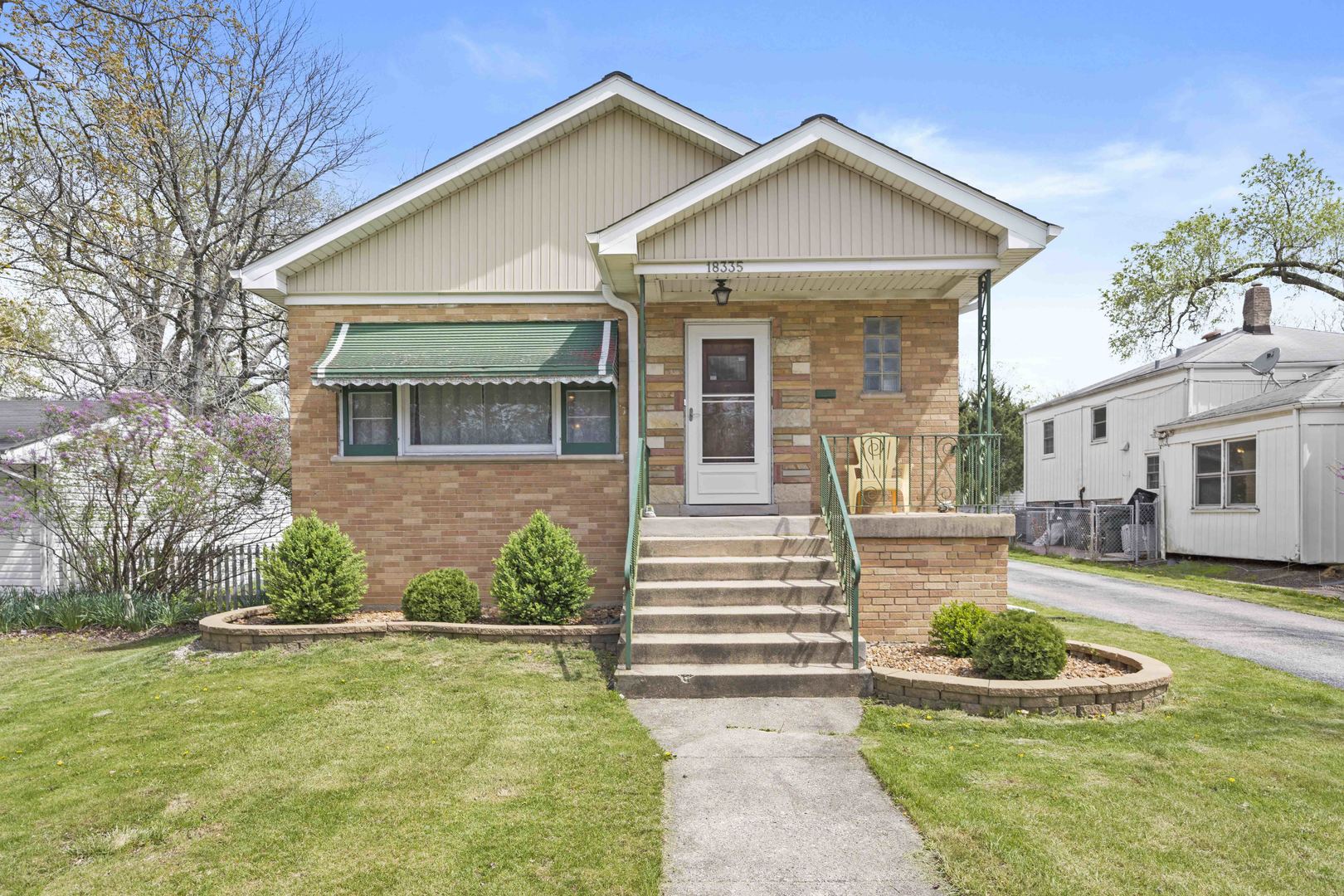 a front view of a house with a yard and potted plants