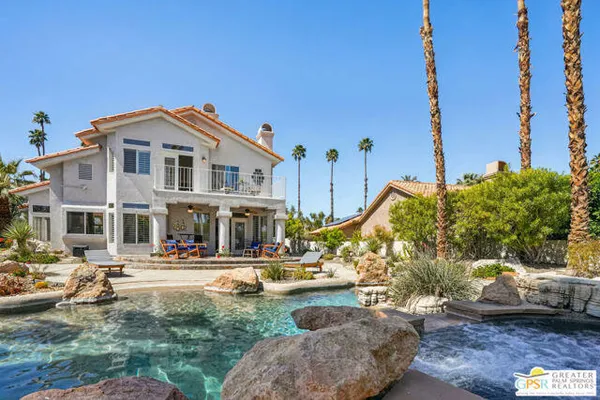 a view of a swimming pool with a patio and a yard