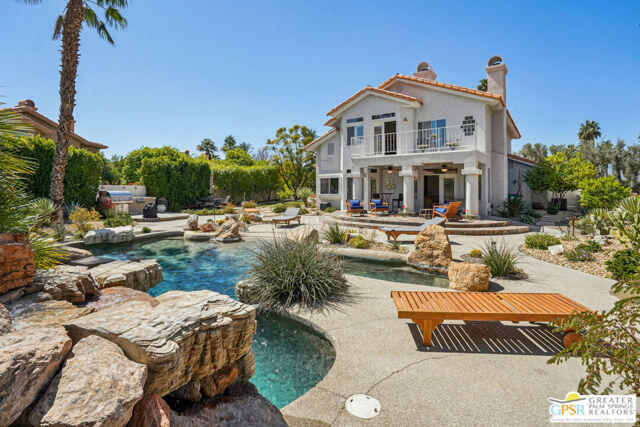 364 Oakmont Drive Palm Desert, CA 92211 - Photo 12 of 74 a front view of a house with a garden and lake view