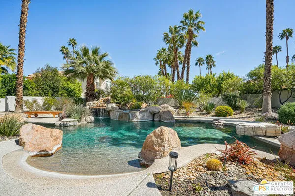 a view of a backyard with swimming pool and sitting area