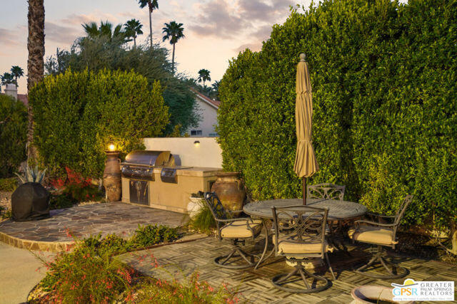 364 Oakmont Drive Palm Desert, CA 92211 - Photo 25 of 74 a view of a patio with table and chairs with wooden fence and plants