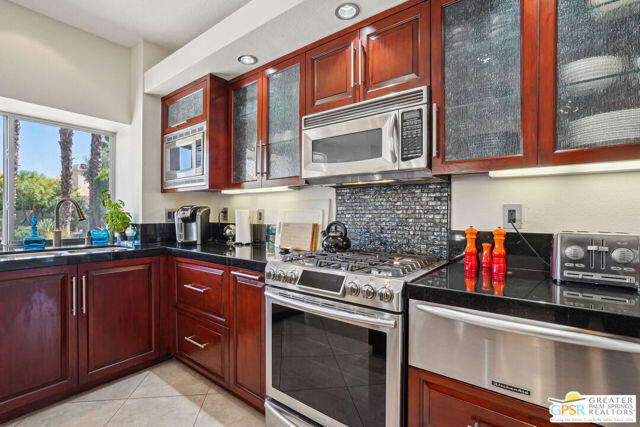 364 Oakmont Drive Palm Desert, CA 92211 - Photo 52 of 74 a kitchen with stainless steel appliances granite countertop a sink dishwasher stove and cabinets