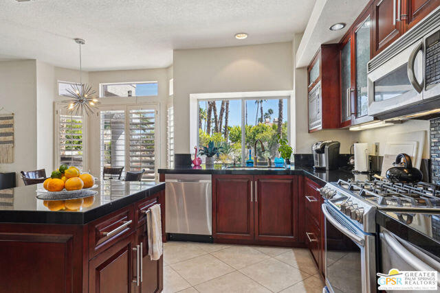 364 Oakmont Drive Palm Desert, CA 92211 - Photo 53 of 74 a kitchen with stainless steel appliances granite countertop a stove a sink and a microwave