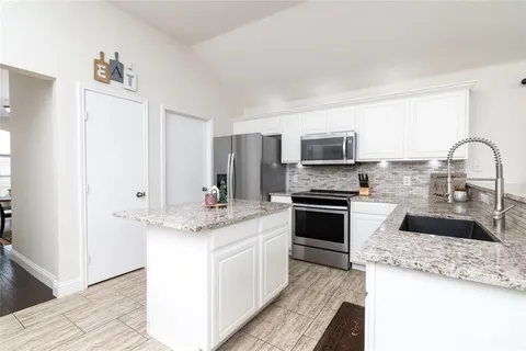 a kitchen with stainless steel appliances granite countertop a stove top oven a sink and dishwasher