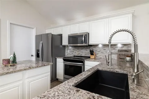 a kitchen with stainless steel appliances granite countertop a sink stove and refrigerator