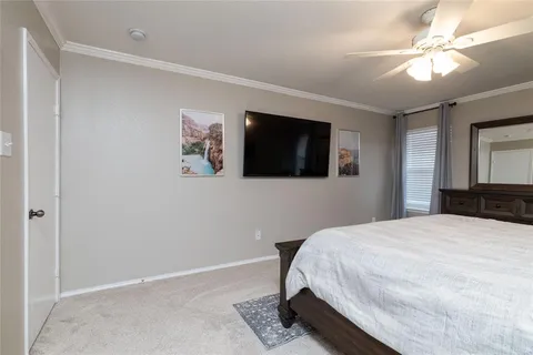 a spacious bedroom with a bed and a flat screen tv