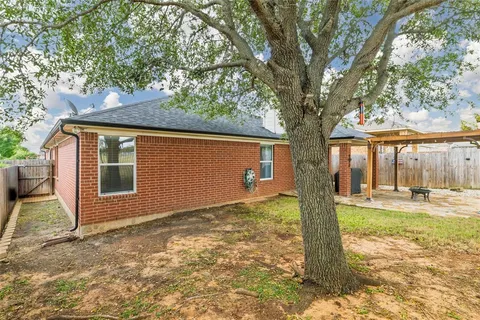 a view of a house with backyard and tree