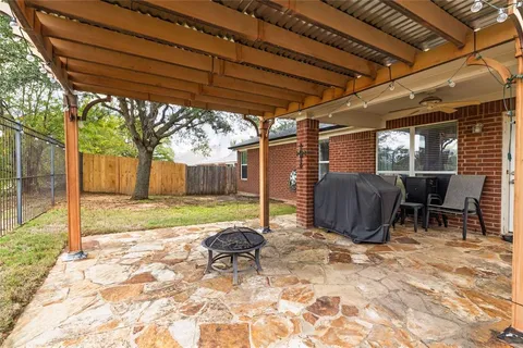 a view of a backyard with table and chairs with wooden fence and plants