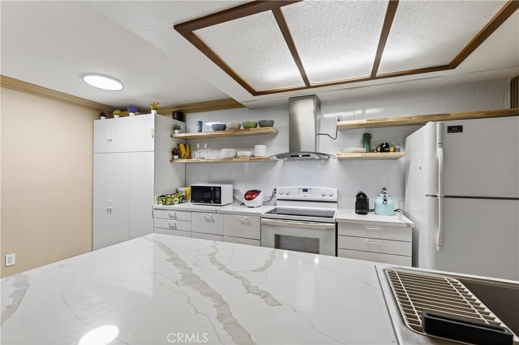 3535 Banbury Drive, Unit 14 Riverside, CA 92505 - Photo 15 of 17 a kitchen with a refrigerator and white cabinets